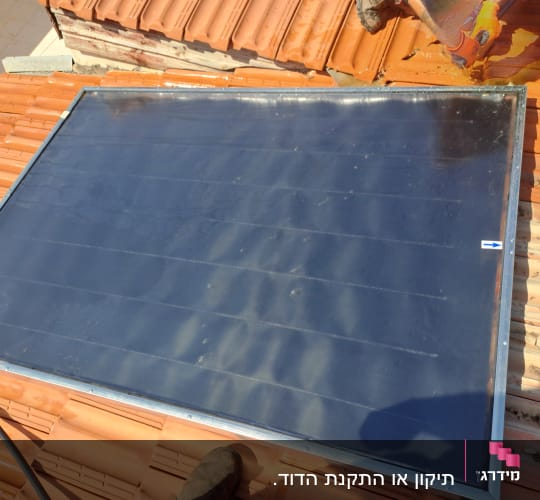 קולטן שמש מותקן על גג רעפים אדומים